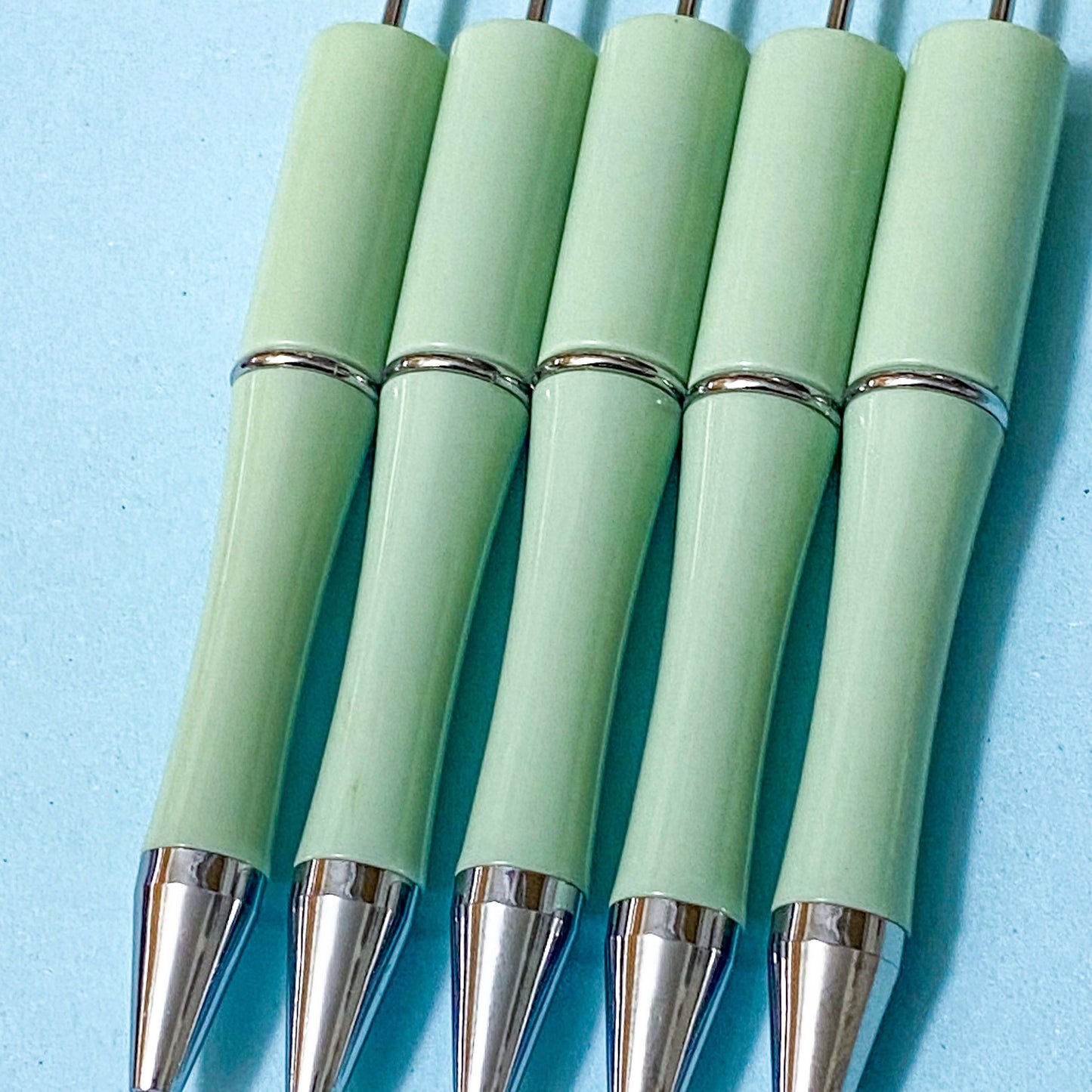 sage or pistachio green pen blank on a blue background