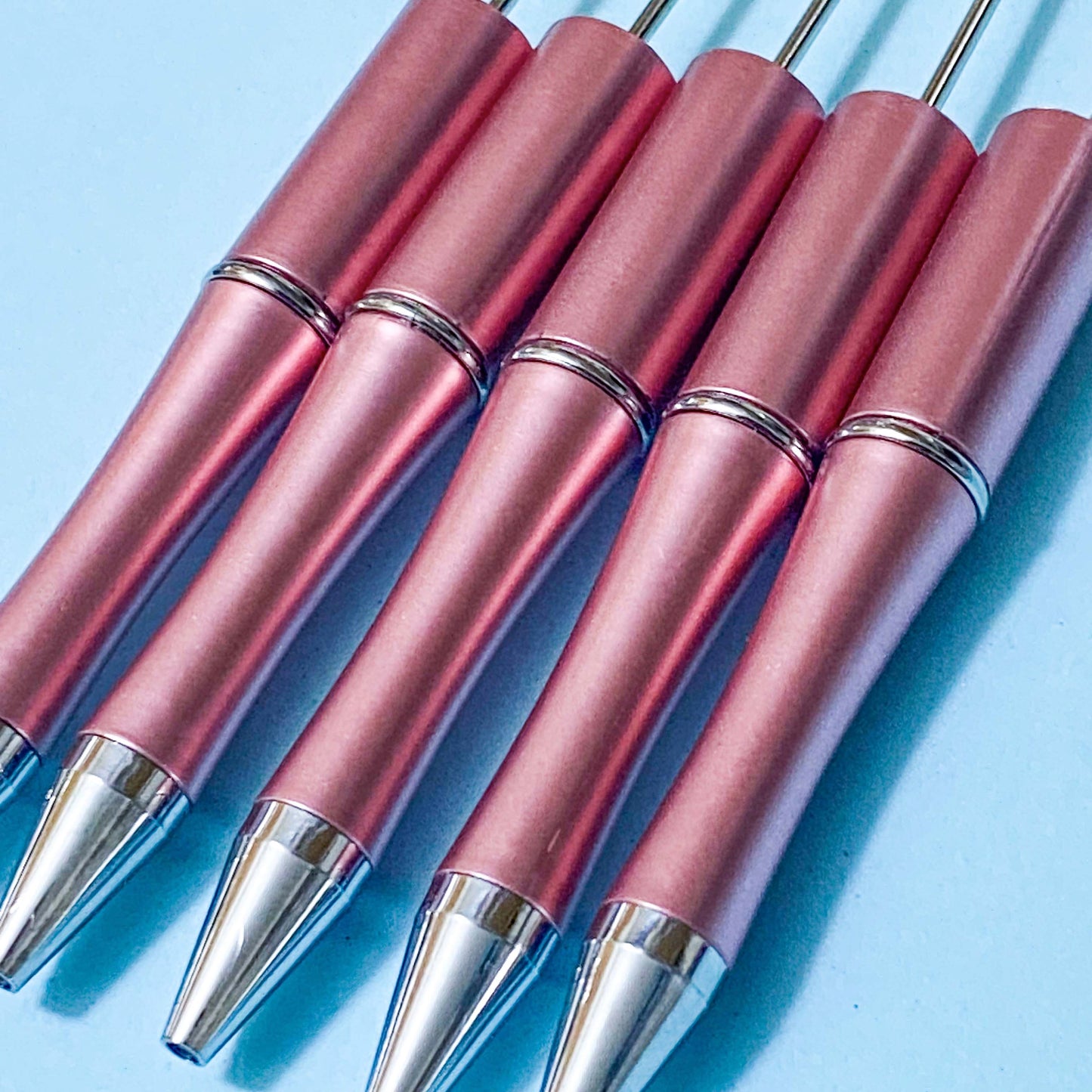 deep gold rose pink metallic pen blanks on a blue background