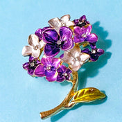 Floral hydrangea brooch with purple flowers and gold leaves on a blue background