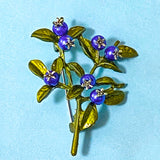 blueberry Brooch with blue berries and green leaves on a light blue background