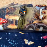 mushroom themed gift set with lined canvas pouch, vintage style bookmark, woodland scrapbook papers and clear mushroom stickers on wooden background