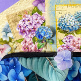 blue hydrangea letterbox gift set with canvas floral pouch, hydrangea black ink pen, enamel blue flower metal brooch, vintage botanical postcards and clear hydrangea stickers. uk cute gifts shop.