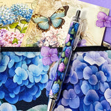 blue hydrangea letterbox gift set with canvas floral pouch, hydrangea black ink pen, enamel blue flower metal brooch, vintage botanical postcards and clear hydrangea stickers. uk cute gifts shop.