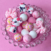 pastel pink silicone bead craft bundles featuring a cute farm black and white cow focal bead or a pink patterned bead with coordinating pink white and floral round silicone beads. uk cute craft supplies shop.