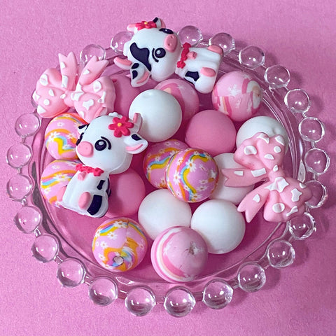 pastel pink silicone bead craft bundles featuring a cute farm black and white cow focal bead or a pink patterned bead with coordinating pink white and floral round silicone beads. uk cute craft supplies shop.