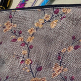autumn hedgerow floral canvas pouch with taupe background, creamy flowers and burgundy rose hips, zip fastening and textured fabric. For journaling, pencil case or cosmetic bag. Uk gifts shop.