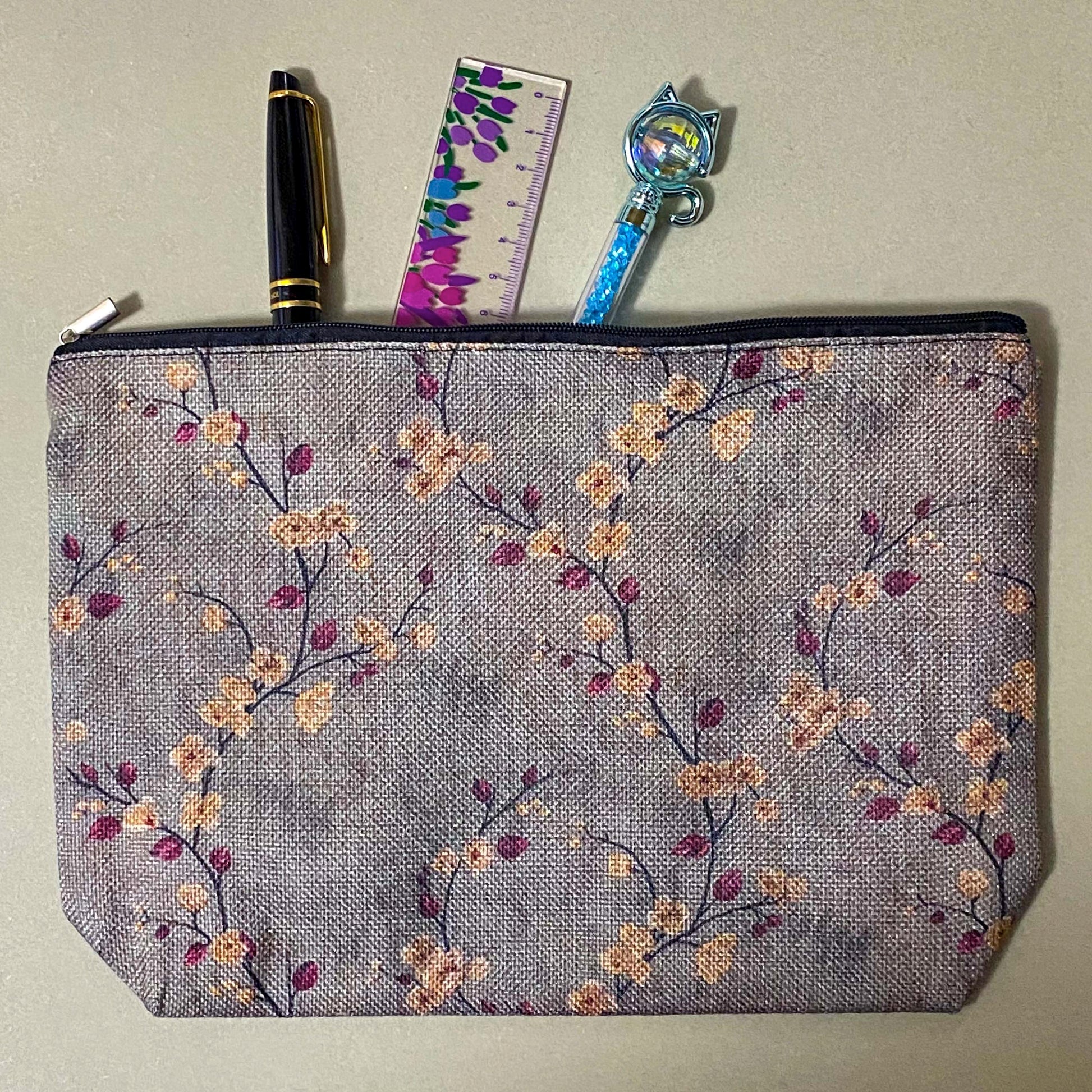 autumn hedgerow floral canvas pouch with taupe background, creamy flowers and burgundy rose hips, zip fastening and textured fabric. For journaling, pencil case or cosmetic bag. Uk gifts shop.