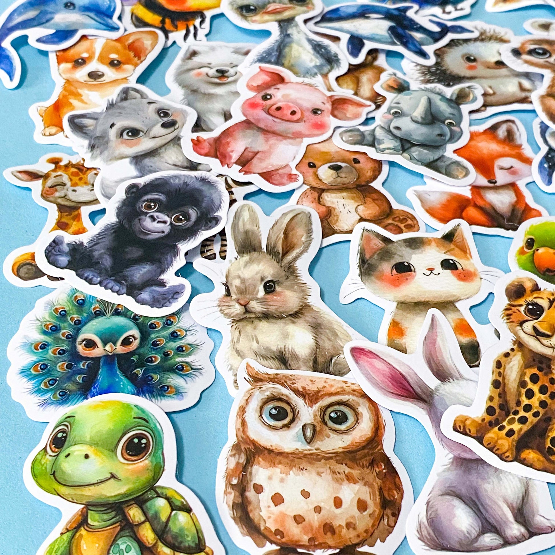 large cute and cuddle kawaii animals silk finish laptop stickers set of 50 on a pale blue background including turtle, owl, rabbit, cat and gorilla