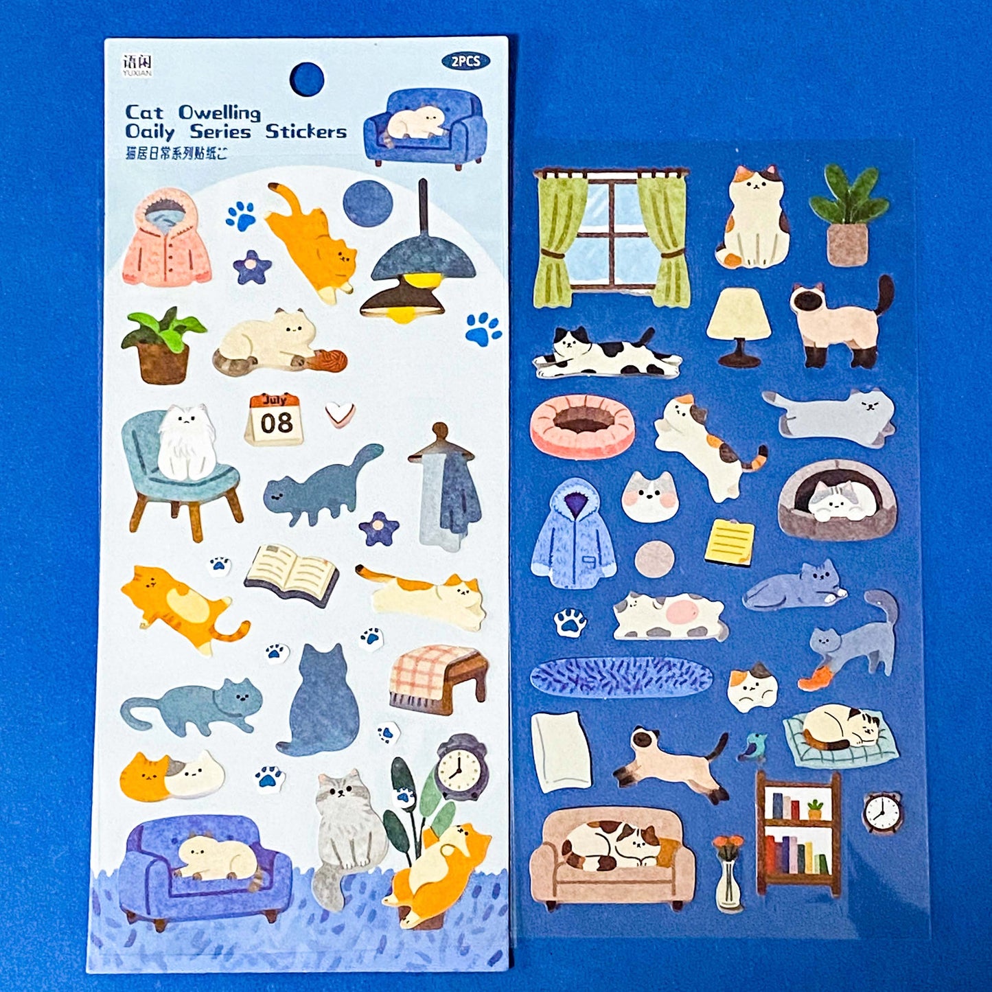 the secret life of cats matte clear sticker PET pack of 2 sheets featuring cosy illustrated cats and home scenes. Choose from the blue sitting room, the moonlit music room or the little cat cafe. UK stationery shop.