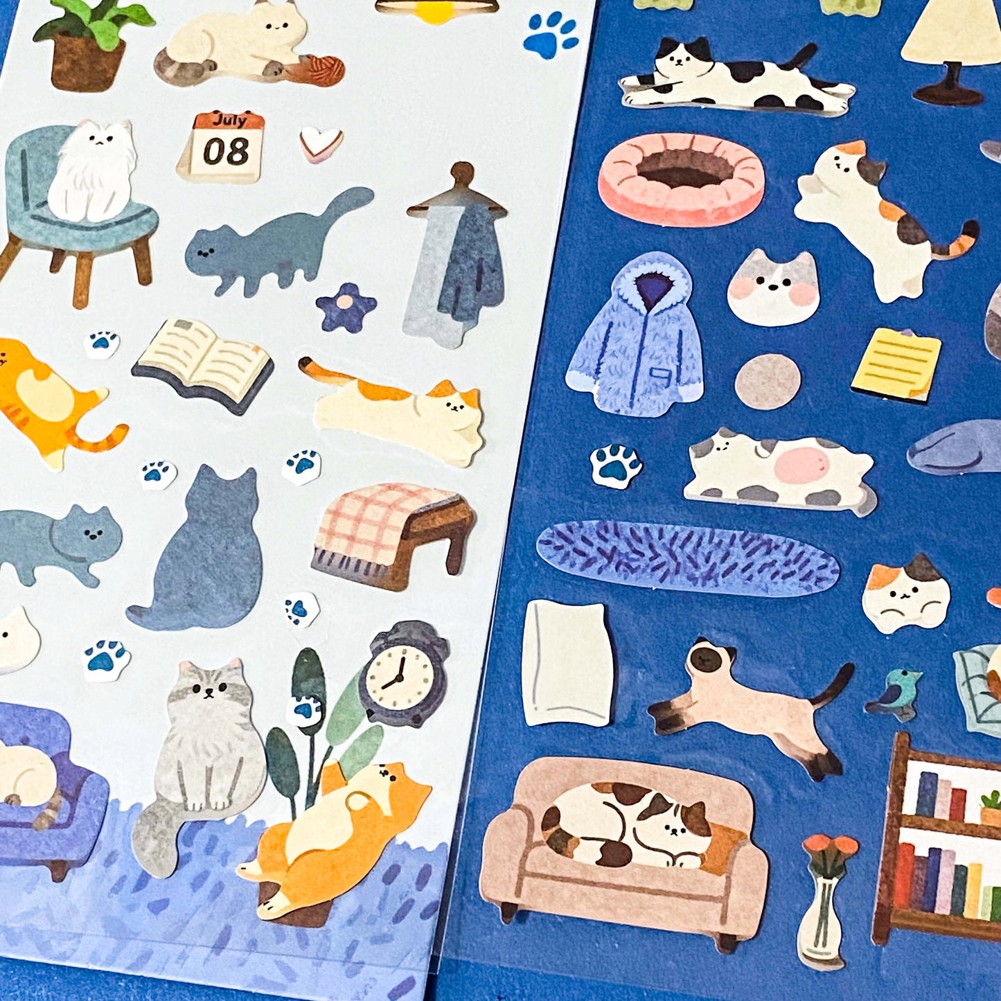 the secret life of cats matte clear sticker PET pack of 2 sheets featuring cosy illustrated cats and home scenes. Choose from the blue sitting room, the moonlit music room or the little cat cafe. UK stationery shop.