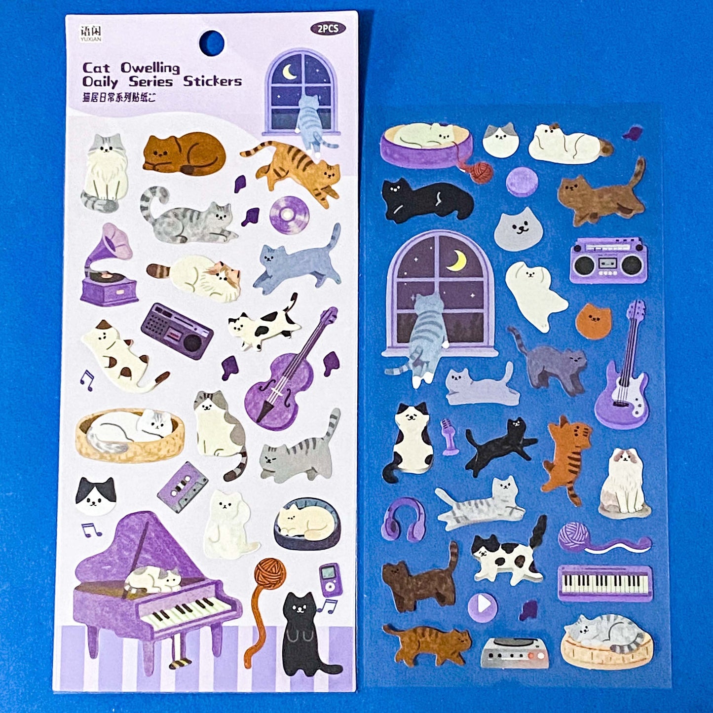 the secret life of cats matte clear sticker PET pack of 2 sheets featuring cosy illustrated cats and home scenes. Choose from the blue sitting room, the moonlit music room or the little cat cafe. UK stationery shop.