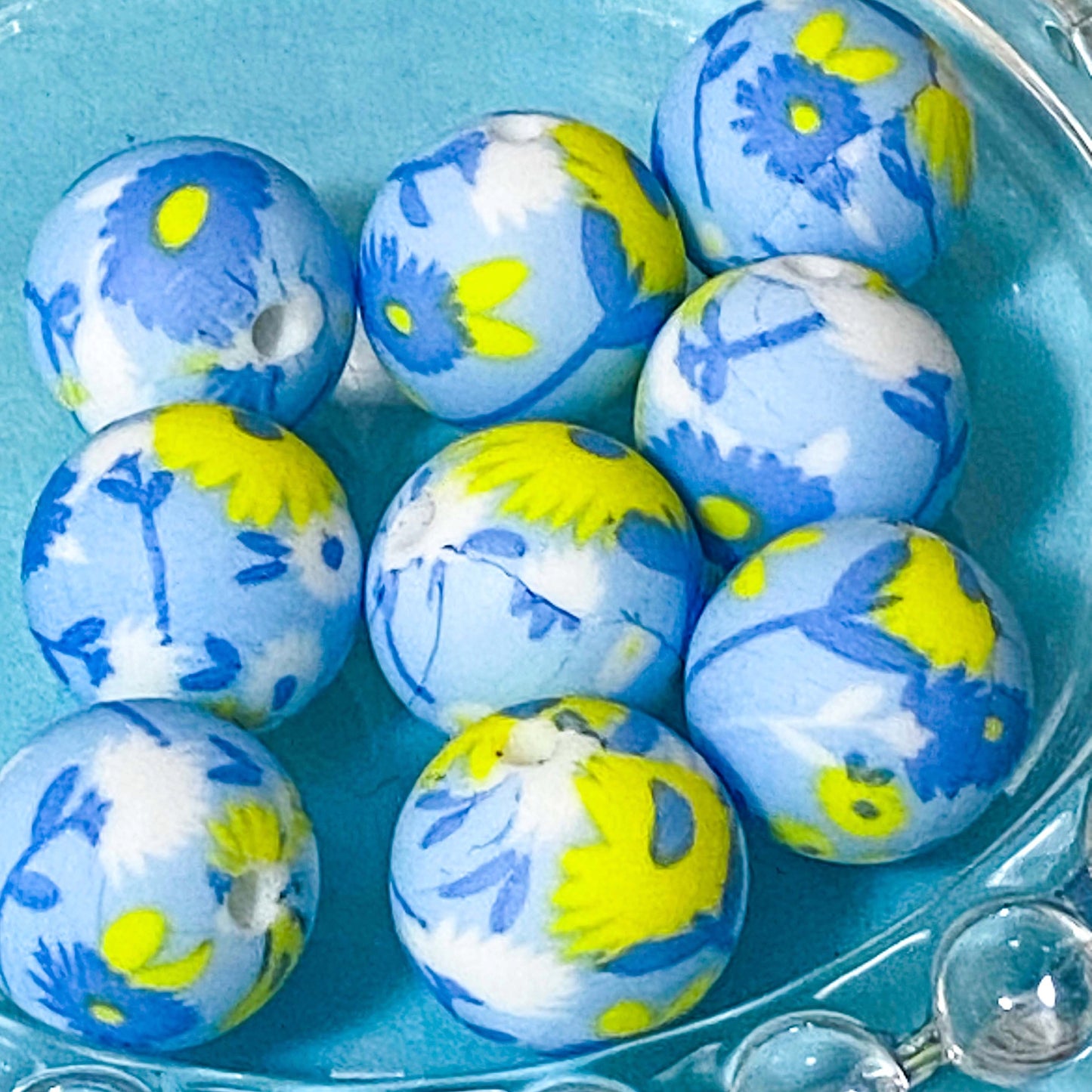 Blue and yellow daisy silicone beads in a clear container