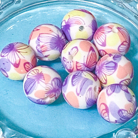 Colorful butterfly-patterned silicone beads on a blue plate