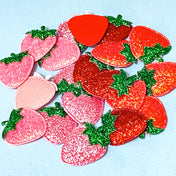 glittery and iridescent strawberry fabric patches on a blue background
