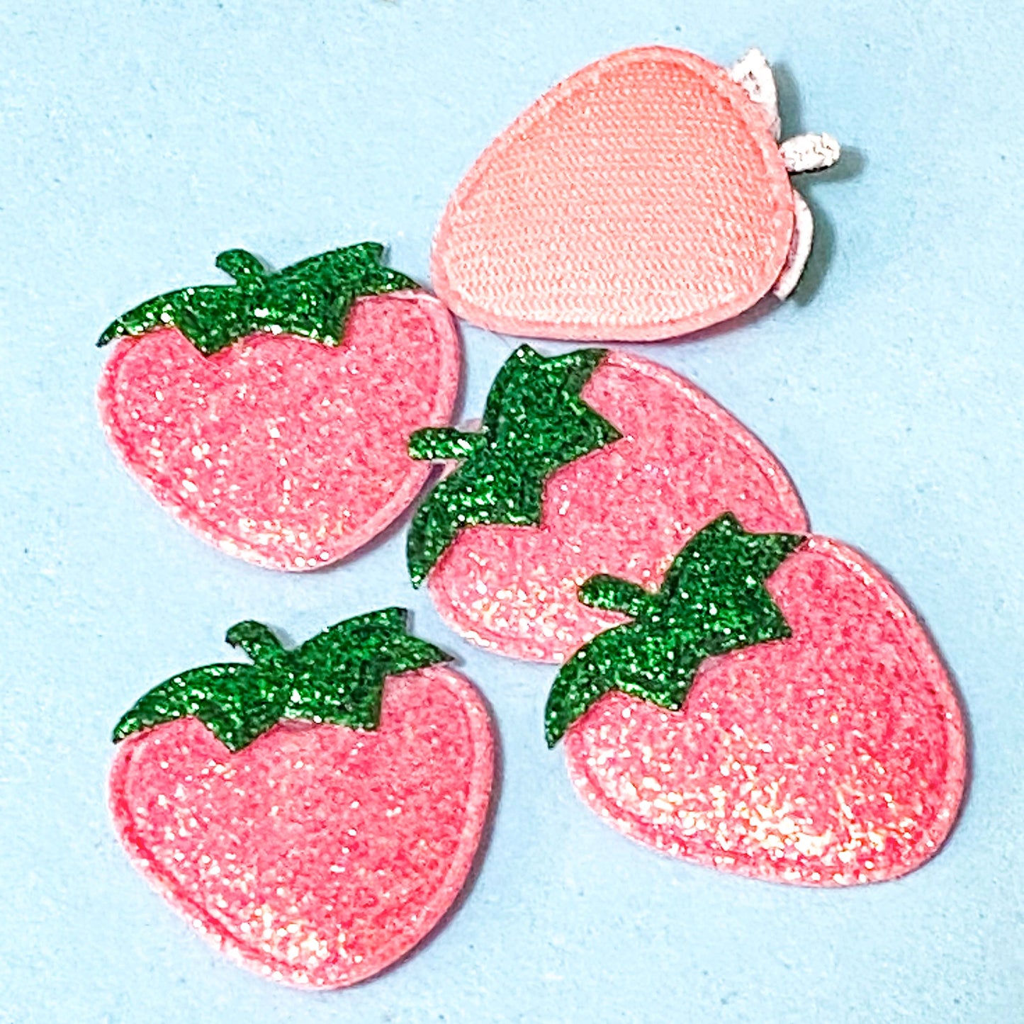 iridescent shimmery strawberry applique on a blue background