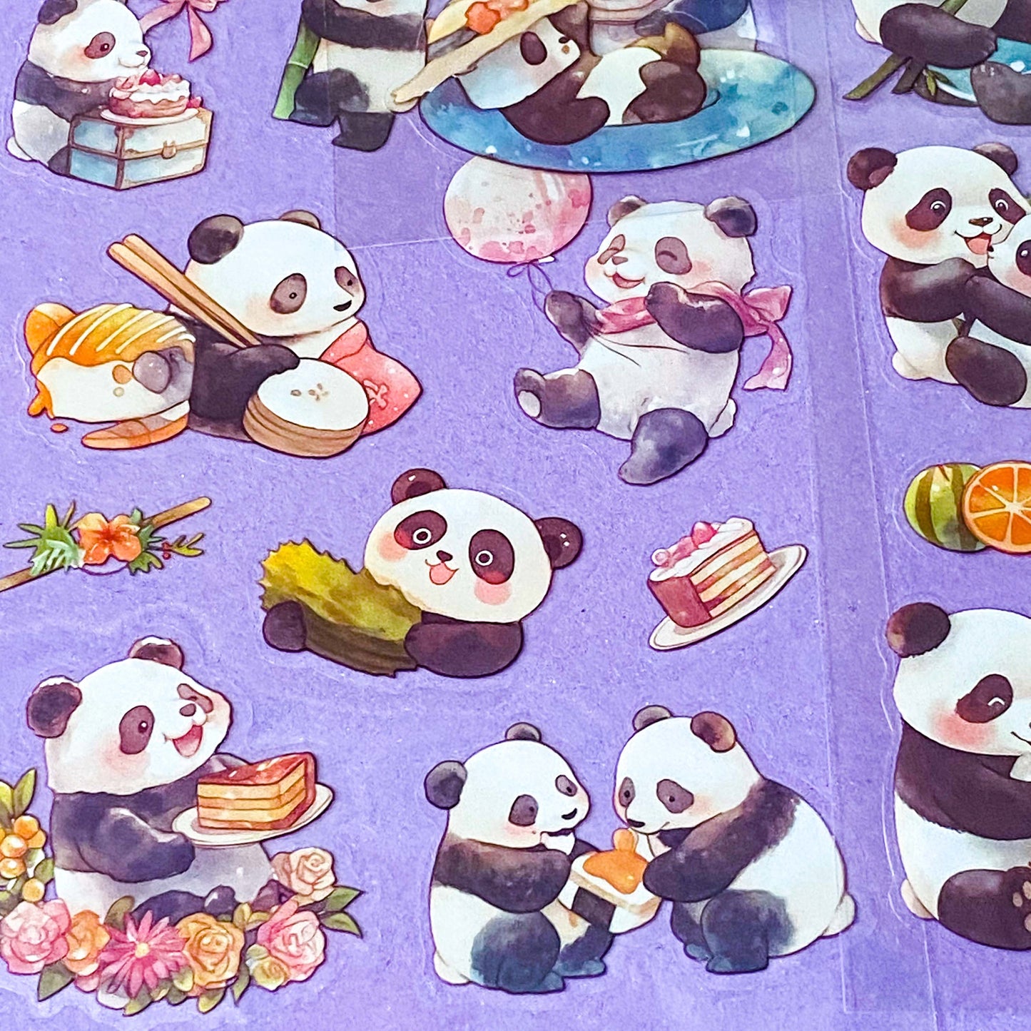 close up of clear plastic sticker sheets with cute panda illustrations on a purple background