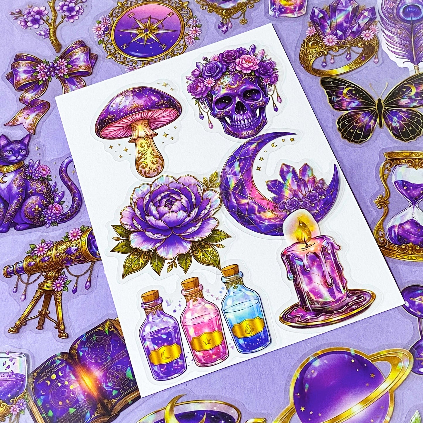 50 different violet oracle witchcore peT stickers featuring crystal balls, tarot cards, butterflies, celestial eyes, candle, skull, moons, potions, flowers, magical purple illustrations. uk stationery gift shop.