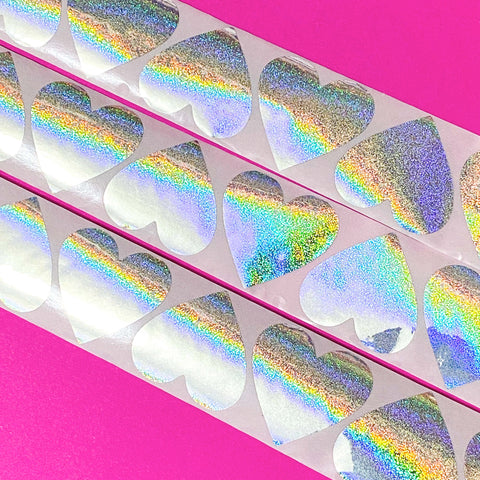Holographic large 38mm silver heart-shaped stickers with rainbow glitter  on a pink background
