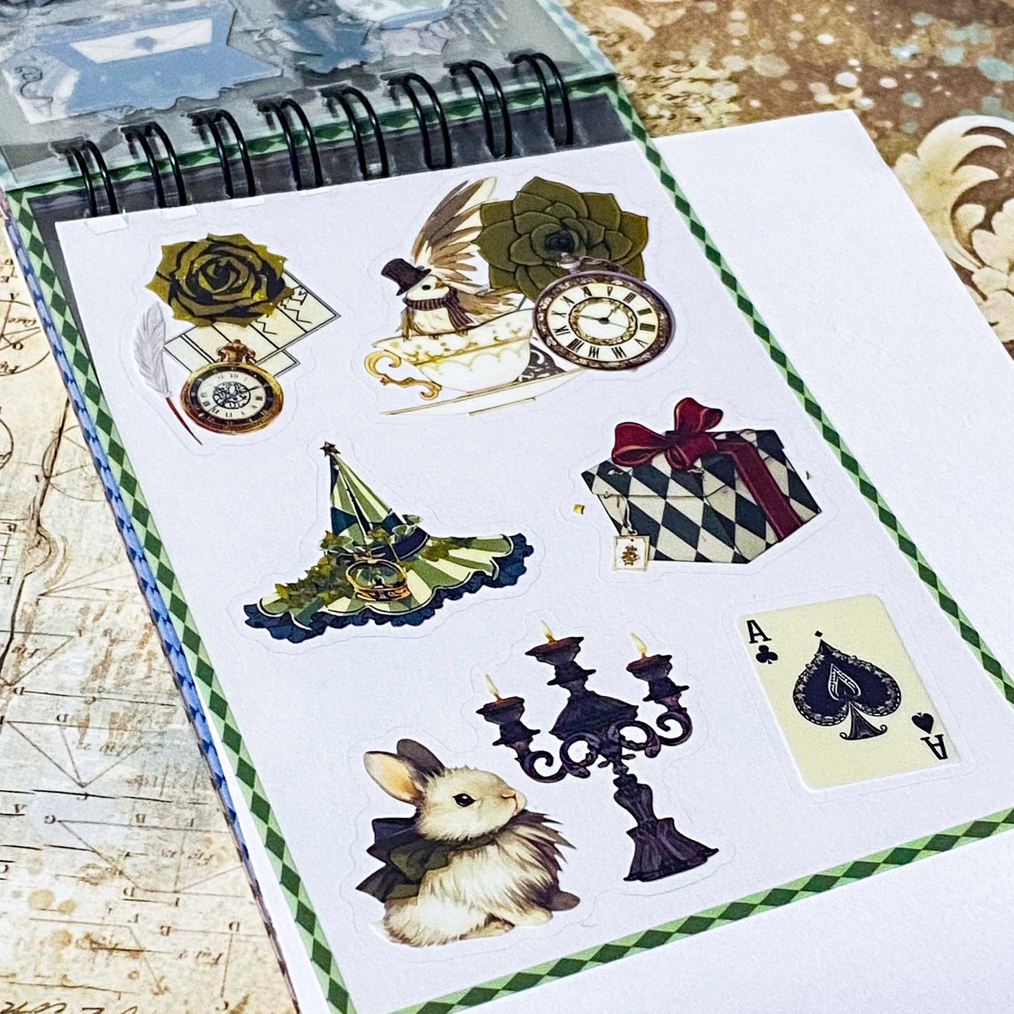 small spiral bound curiouser and curiouser alice clear PET sticker folio featuring fantasy stickers with mushrooms, roses, playing cards, rabbits and vintage gothic fairytale artwork
