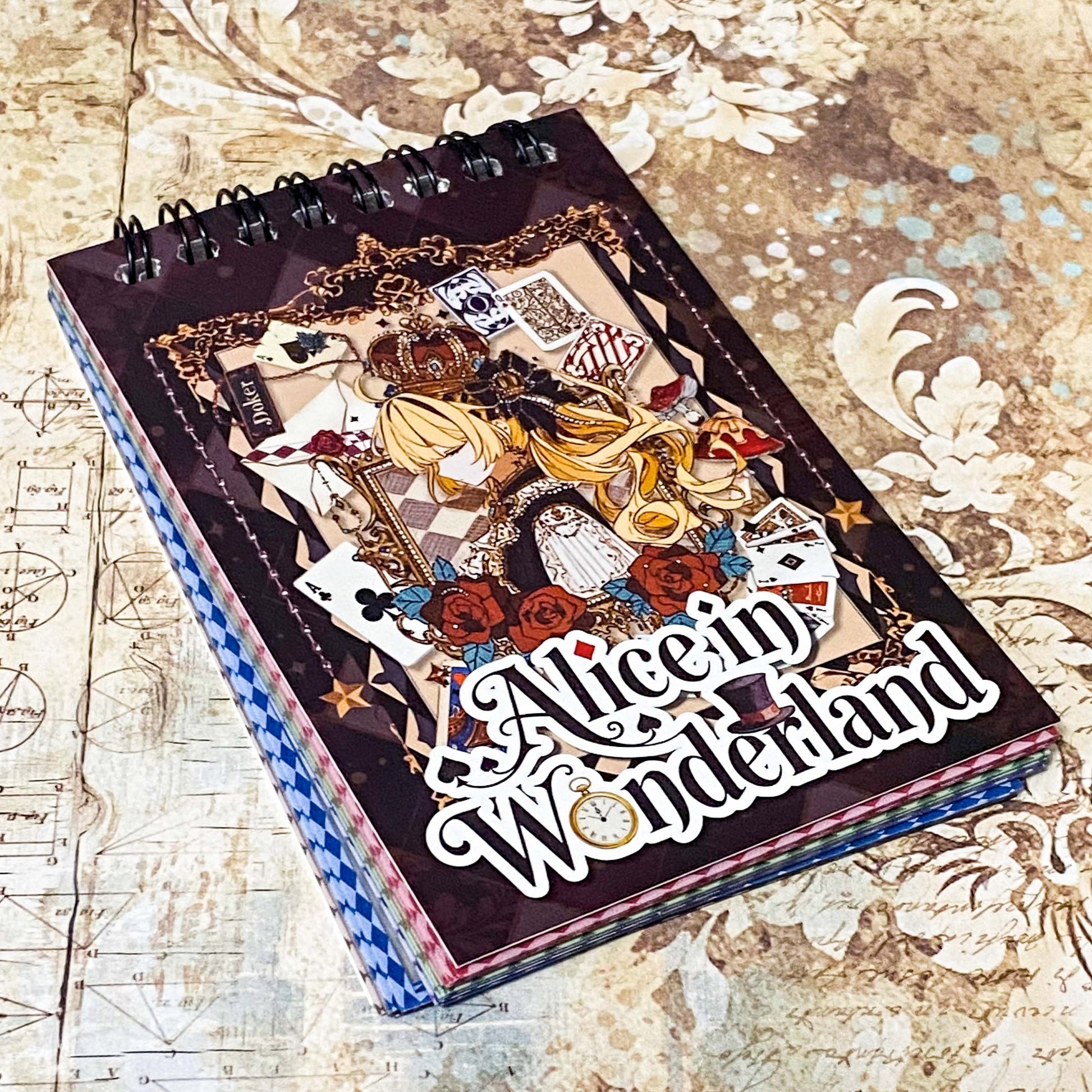 small spiral bound curiouser and curiouser alice clear PET sticker folio featuring fantasy stickers with mushrooms, roses, playing cards, rabbits and vintage gothic fairytale artwork