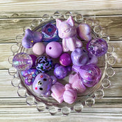 large purple and lilac acrylic and silicone beads bundle of 22 with designs including bear, cat, hot air balloon and bow. For making beaded pens and jewellery. `uk crafts bundle. Pretty beading kit.