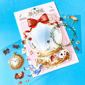 large alice inspired falling into wonderland sticker set with oversized now globe scene card, transparent PET stickers, pocket watch, roses and playing cards details on pink backing card with bow