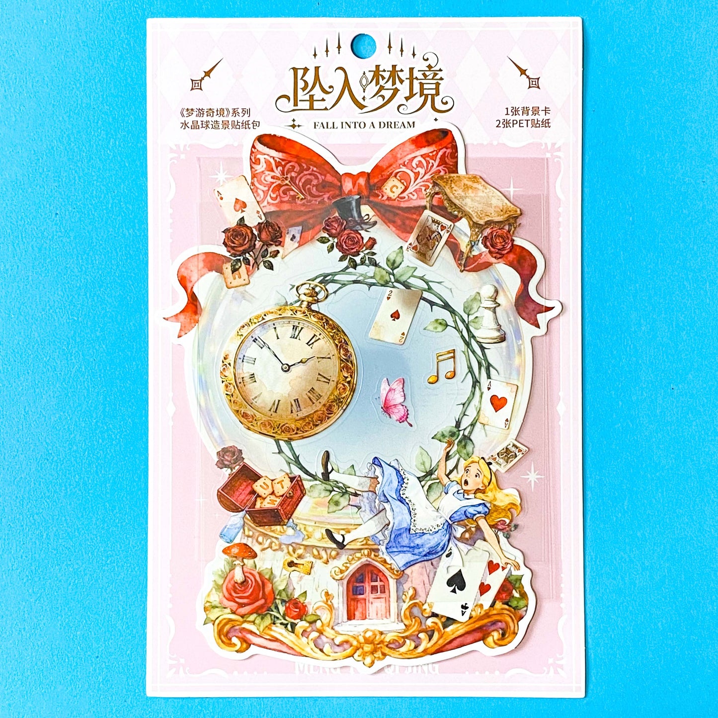 large alice inspired falling into wonderland sticker set with oversized now globe scene card, transparent PET stickers, pocket watch, roses and playing cards details on pink backing card with bow