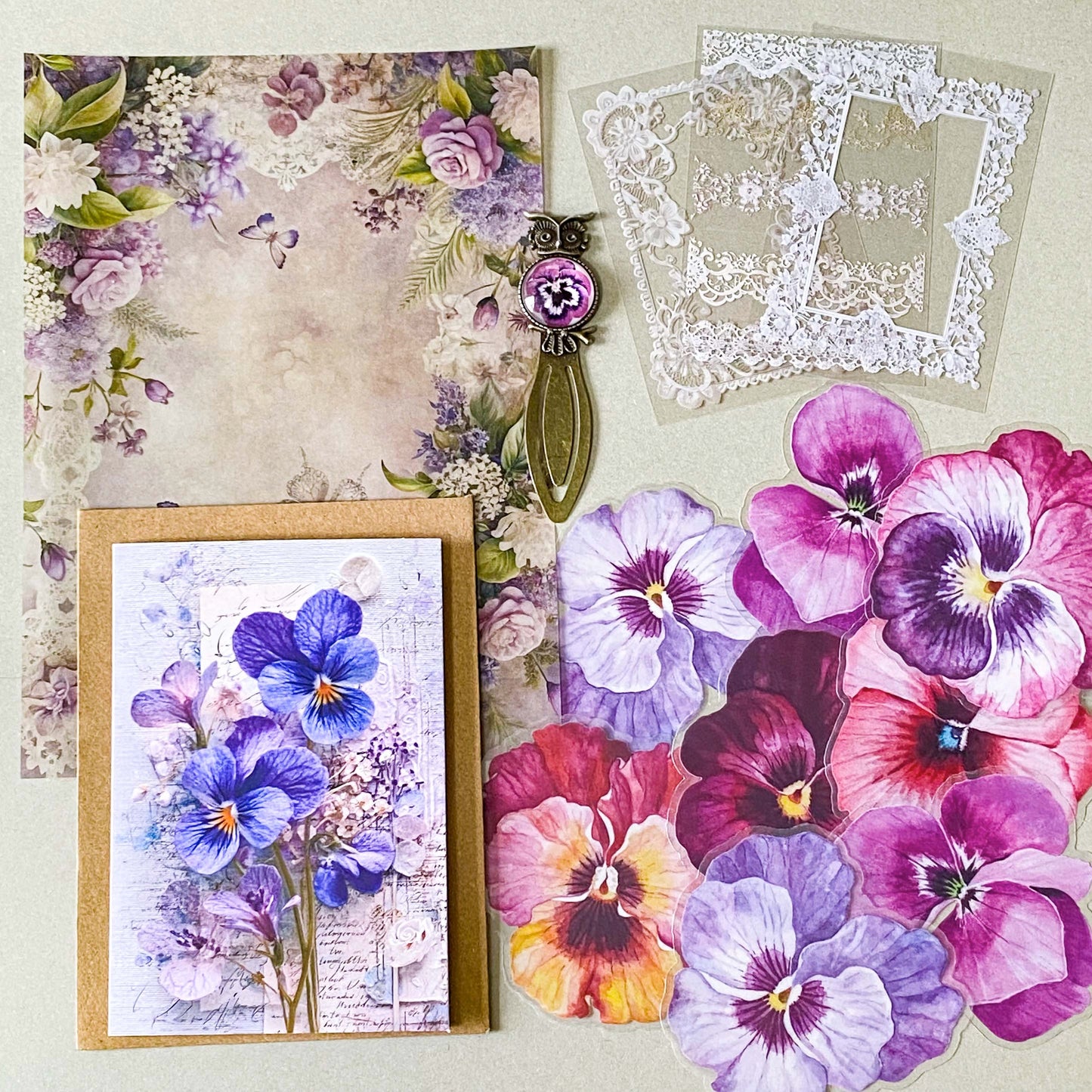 victorian pansy themed letterbox gift set with floral pouch, botanical stickers, vellum journaling sheets and antique style metal and glass bookmark in shades of purple, yellow and blue