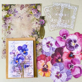 victorian pansy themed letterbox gift set with floral pouch, botanical stickers, vellum journaling sheets and antique style metal and glass bookmark in shades of purple, yellow and blue