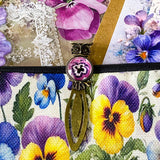 victorian pansy themed letterbox gift set with floral pouch, botanical stickers, vellum journaling sheets and antique style metal and glass bookmark in shades of purple, yellow and blue