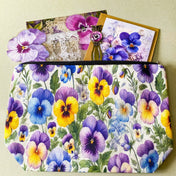 victorian pansy themed letterbox gift set with floral pouch, botanical stickers, vellum journaling sheets and antique style metal and glass bookmark in shades of purple, yellow and blue