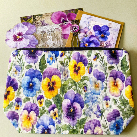 victorian pansy themed letterbox gift set with floral pouch, botanical stickers, vellum journaling sheets and antique style metal and glass bookmark in shades of purple, yellow and blue