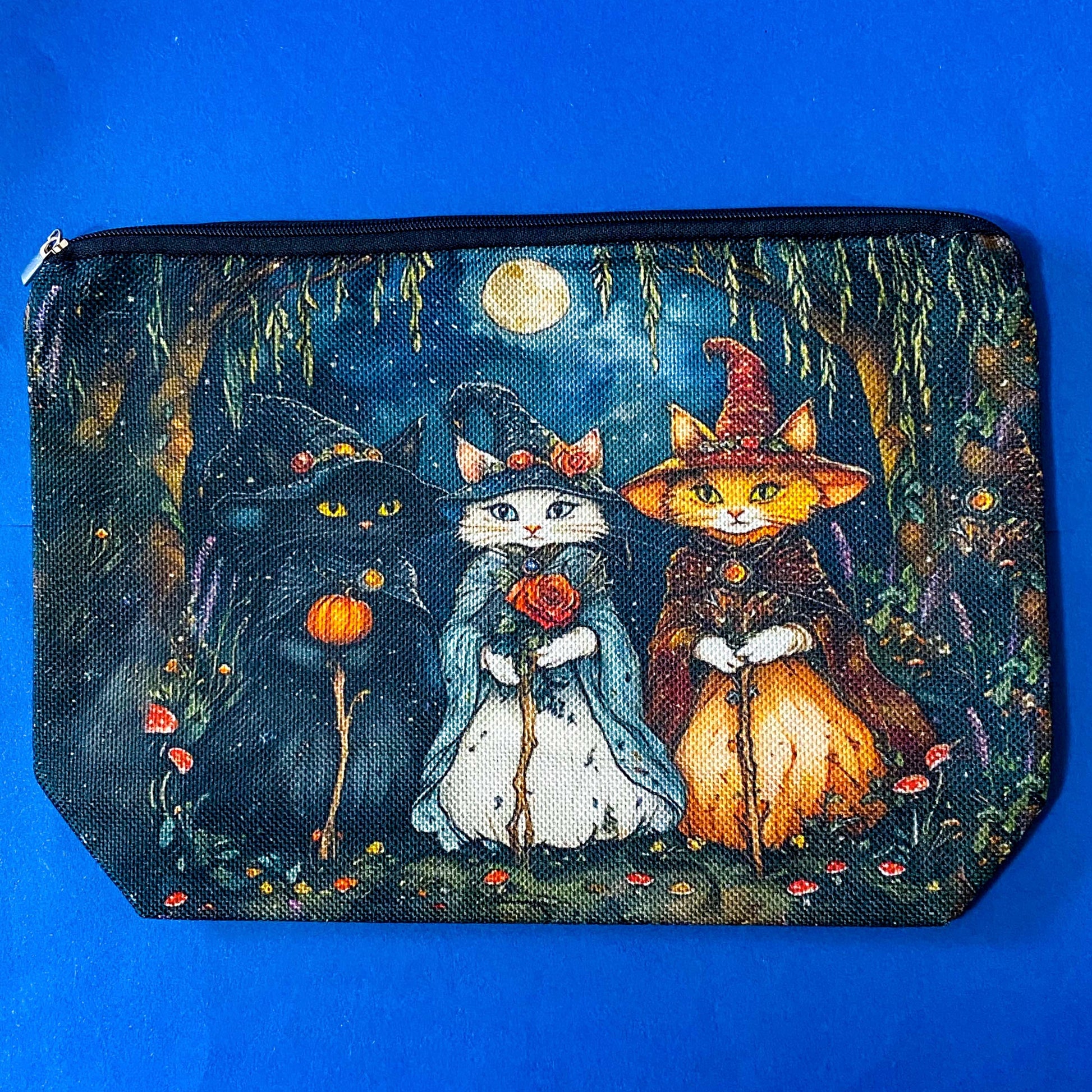 textured canvas pouch featuring three witch cats gathering beneath a full moon in an enchanted woodland with willow branches, mushrooms and autumn leaves. Dark blue, green, storm grey and black. Uk letterbox gifts. Halloween theme.