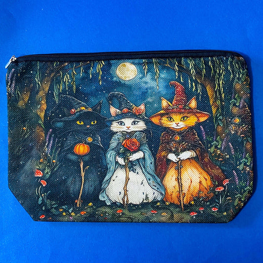 textured canvas pouch featuring three witch cats gathering beneath a full moon in an enchanted woodland with willow branches, mushrooms and autumn leaves. Dark blue, green, storm grey and black. Uk letterbox gifts. Halloween theme.