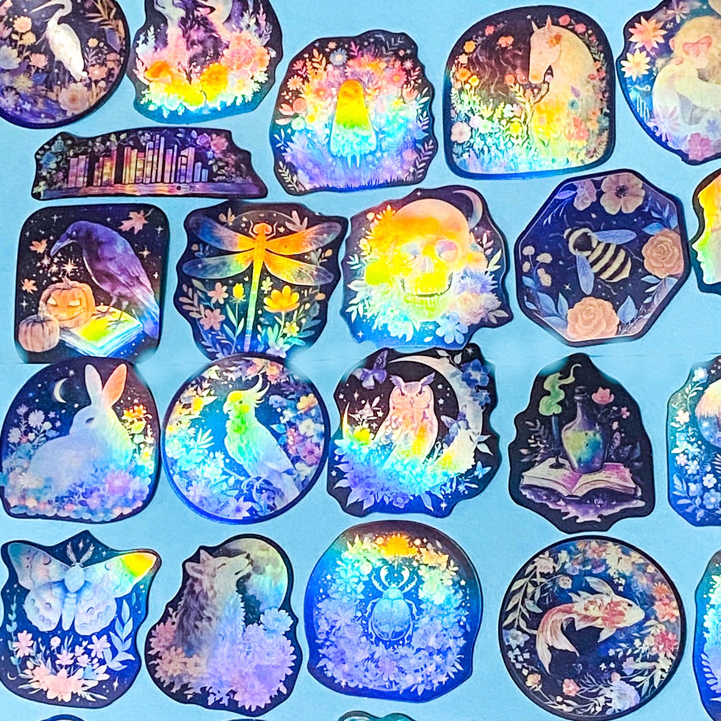 Collection of colorful, iridescent stickers with various designs on a blue background