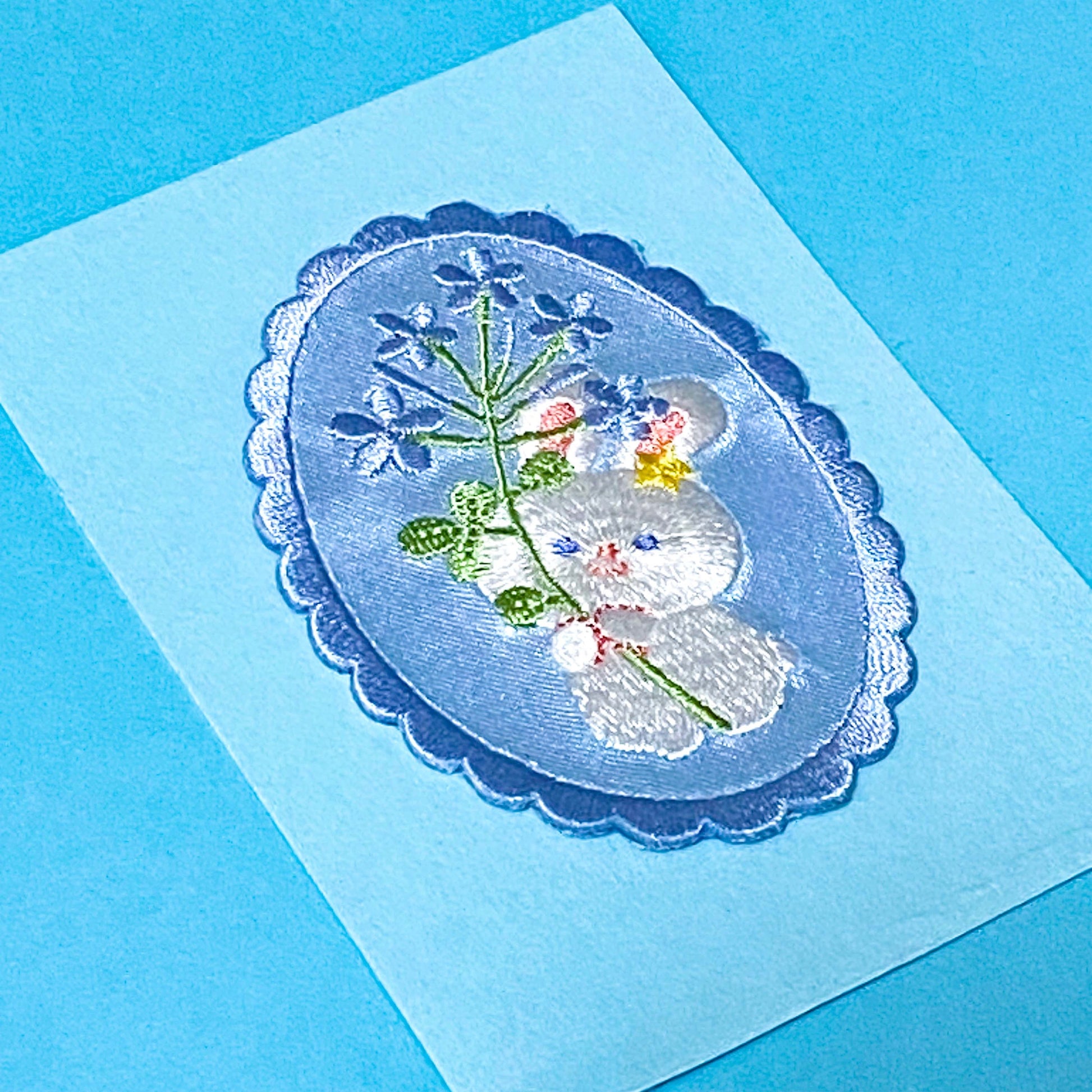 white bunny iron on fabric applique patch on a blue background