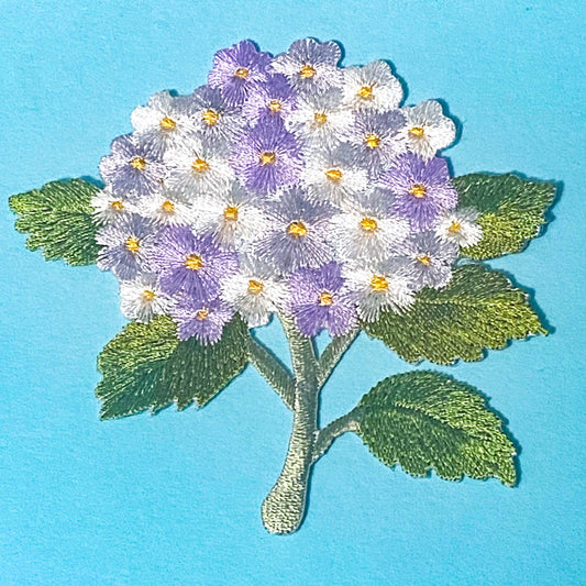 iron on embroidery patch of a lilac and white hydrangea on a blue background