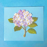 large embroidery iron on fabric hydrangea patch with lilac and white flowers on a blue background