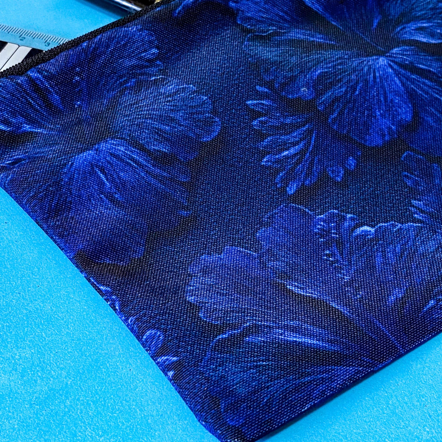 very dark inky blue canvas zip pouch with floral hibiscus deep design on both sides. Midnight botanical design with leaves and petals. floral gifts uk.