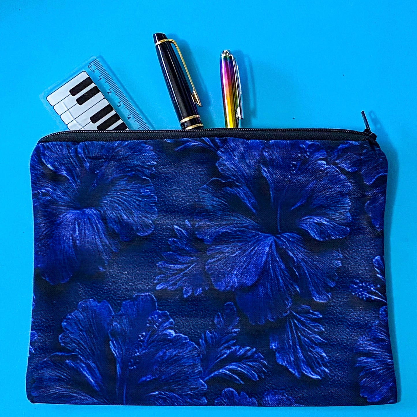 very dark inky blue canvas zip pouch with floral hibiscus deep design on both sides. Midnight botanical design with leaves and petals. floral gifts uk.