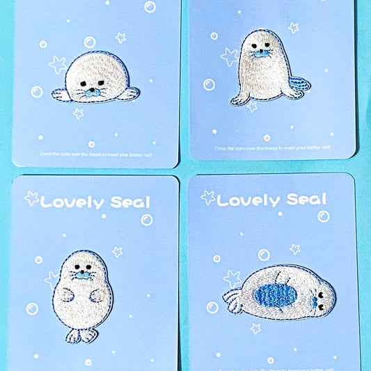 four embroidered fabric iron on seal applique  patches on a blue background