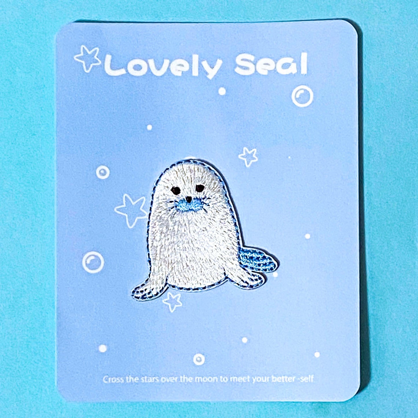Embroidered patch of a seal on a blue card with 'Lovely Seal' text.