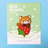 Embroidered patch of a red panda on a strawberry with text on a green card, against a blue background.