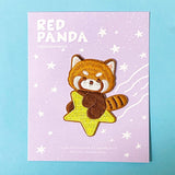 Red panda patch on a purple card with star patterns against a blue background