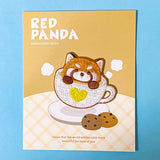 Embroidery patch with a red panda in a teacup on a beige card with text.
