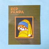 Embroidered patch of a red panda wearing a blue headband and yellow scarf on a green card with 'Red Panda' text. The Girl With The pearl Earring oil painting