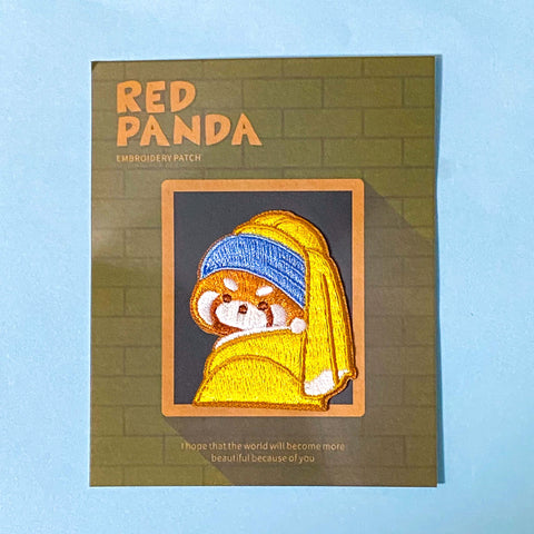 Embroidered patch of a red panda wearing a blue headband and yellow scarf on a green card with 'Red Panda' text. The Girl With The pearl Earring oil painting