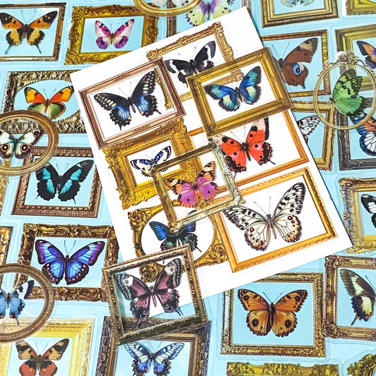 set of 52 clear plastic gold framed butterfly stickers like miniature works of art on a blue background