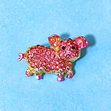 little pink pig sparkly brooch on gold tone metal with sparkly rhinestones on a blue background