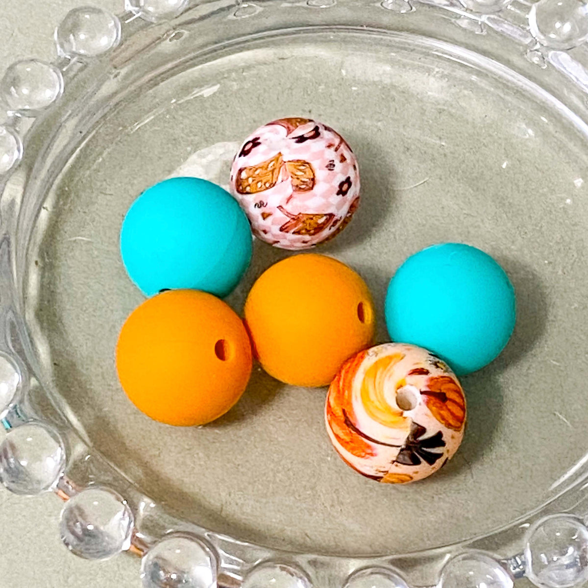 cosy autumn silicone bead bundle with bright teal green, mustard orange round beads and patterned pumpkin and cute drink beads with kawaii drink cup jumbo topper beads. uk craft supplies for making beaded pens.